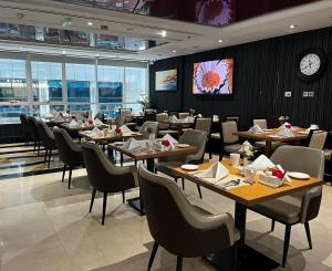 a restaurant with tables and chairs and a clock at Al Diar Sawa Hotel Apartments in Abu Dhabi