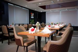 a dining room with wooden tables and chairs at Al Diar Sawa Hotel Apartments in Abu Dhabi +37 photos