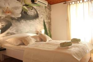a white bed in a bedroom with a wall at House Roso in Makarska