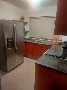 a kitchen with a stainless steel refrigerator and a sink at Cancun in Cancún