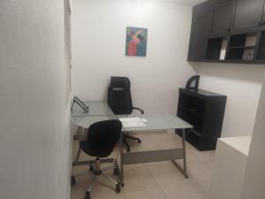 an office with a glass desk and a chair at Cancun in Cancún +2 photos