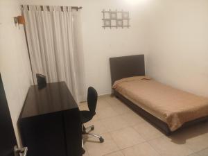 a bedroom with a bed and a desk with a computer at Cancun in Cancún