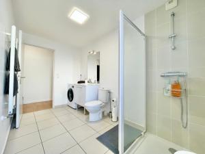 a bathroom with a shower and a toilet and a sink at ParcAppart 5 - Terrasse - Parking - Netflix in Lanester +8 photos