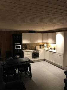 a kitchen with white cabinets and a table with chairs at Trysilmountainlodge in Hovi
