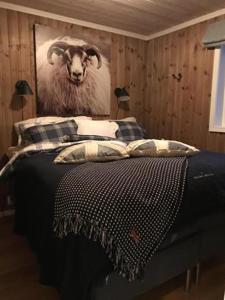 a bedroom with a bed with a picture of a sheep at Trysilmountainlodge in Hovi +1 photo
