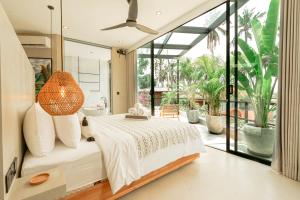 Un dormitorio con una cama y una ventana grande. en Makai Kedungu, en Tanah Lot 47 fotos más