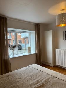 a bedroom with a bed and a large window at Vejle Liv in Vejle +14 photos