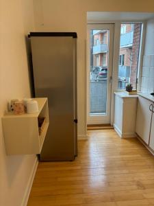 a stainless steel refrigerator in a kitchen with a window at Vejle Liv in Vejle +16 photos