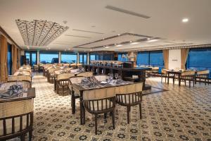 Un comedor con mesas y sillas en un restaurante. en Halong & Lan Ha Cruises, en Ha Long