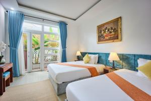 a hotel room with two beds and a window at Nelly Villa Hoi An in Hoi An +64 photos