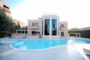 Caves Beach Resort Adults Only في الغردقة: حمام سباحة كبير أمام مبنى