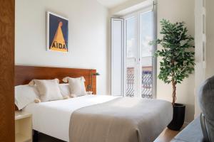 Un dormitorio con una gran cama blanca y una ventana. en Ópera Apartments Alameda, en Sevilla 36 fotos más