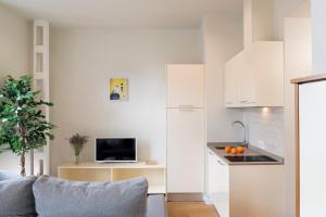 Una sala de estar con un sofá y una cocina. en Ópera Apartments Alameda, en Sevilla