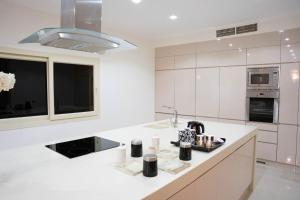 Caves Beach Resort Adults Only في الغردقة: مطبخ أبيض مع حوض وميكروويف