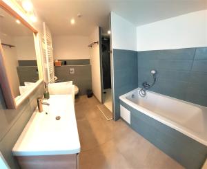 a bathroom with a tub and a sink and a toilet at Le Héron in Thury-Harcourt