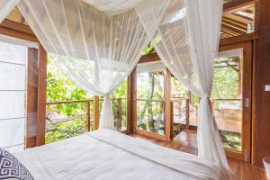 una camera da letto con un letto con zanzariera di Coconut Corner - Ocean View Treehouse a Tanah Lot