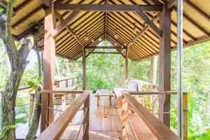pergolato in legno con tavolo su una terrazza in legno di Coconut Corner - Ocean View Treehouse a Tanah Lot