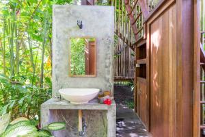 un bagno con lavandino a ciotola su un blocco di cemento di Coconut Corner - Ocean View Treehouse a Tanah Lot