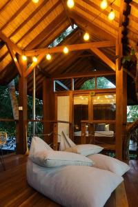 una grande camera con cuscini su un pavimento in legno di Coconut Corner - Ocean View Treehouse a Tanah Lot Altre 37 foto