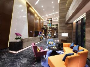 Un vestíbulo con sofás y sillas en un edificio. en Hampton by Hilton Changsha South Railway Station West Square, en Changsha