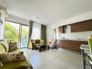 a living room with a couch and a kitchen at Tempo Sea Suits in Kérynia