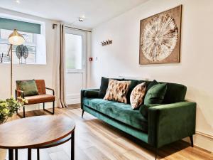 a living room with a green couch and a table at 2-Bed Apartment - For Contractors & Business Travellers - Long Stays Welcome in Exeter