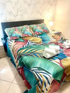 un letto con lenzuola e cuscini colorati di Jordan Apartment a Napoli
