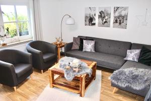 a living room with a couch and two chairs at Ferienwohnung Dörnberg erleben mit Tiere bei Winterberg in Bestwig