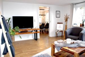 a living room with a tv and a table at Ferienwohnung Dörnberg erleben mit Tiere bei Winterberg in Bestwig