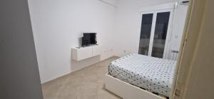 a white room with a bed and a tv at Apparement de type F3 à El-kseur in El Kseur