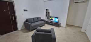 a living room with a couch and a chair and a television at Apparement de type F3 à El-kseur in El Kseur