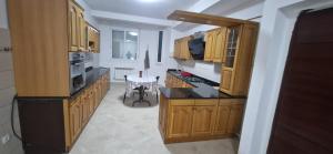 a kitchen with wooden cabinets and a table in it at Apparement de type F3 à El-kseur in El Kseur