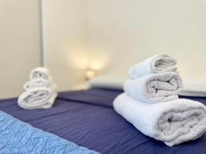 uma pilha de toalhas em cima de uma cama em Vicina al mare con grande giardino - Appartamento Tulipano em Rimini
