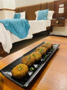 a tray of food on a table next to a bed at Hotel Dileep42 in Lucknow