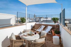 een terras met een tafel en stoelen op een balkon bij Magno Apartments Almansa in Sevilla