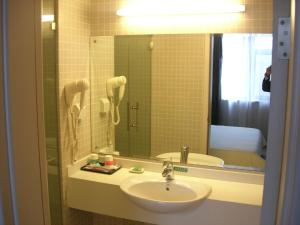 a bathroom with a sink and a mirror at Jinjiang Inn Yanji Railway Station Municipal Government in Yanji +16 photos