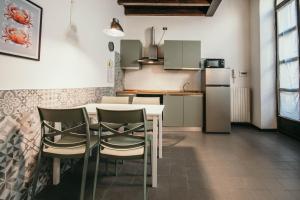 a kitchen with a table and chairs and a refrigerator at Bigattera Apartments in Varese