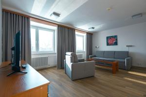 a living room with a couch and a tv at Hotel Garni VŠB TUO in Ostrava