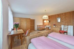 ein Schlafzimmer mit zwei Betten und einem Tisch mit Blumen darauf in der Unterkunft Nussbaum in Brixen