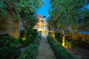 a walkway in front of a building with trees at Viewpoint Boutique Living in Xlendi