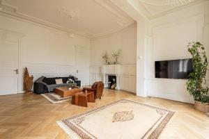 a living room with a couch and a tv at Hôtel particulier - Le 119 in Valenciennes