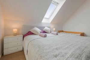 a bedroom with a large white bed with two lamps at Guest House KRISTI in Tuchoměřice