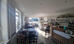Ein Restaurant mit einer Bar mit Stühlen und einem Tresen in der Unterkunft Hotel-Cafe-Lindow in Wenningstedt-Braderup