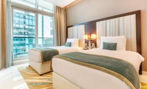 a hotel room with two beds and a window at Nice 2 Bedroom Apartment! 5 Minute walk to Dubai Mall! Burj Khalifa View! in Dubai