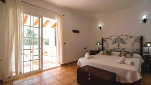 a bedroom with a large bed and a large sliding glass door at Apartamentos Es Pou - Emar Hotels in Sant Ferran de Ses Roques