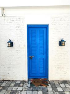 a blue door on a white brick wall with two lights at Casa Del Mar - Sea Facing Villa in Cochin