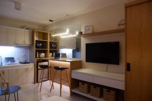 a kitchen with a large flat screen tv on the wall at Lapu2x Studio apartments feels home in Lo-oc
