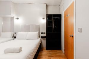 a bedroom with two beds and a black door at Britannia Hyde Park Hotel by PLI in London