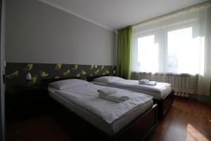 two twin beds in a room with a window at Hotel Piast in Myślibórz