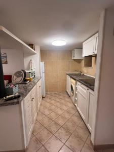 a kitchen with white cabinets and a tile floor at Il Balconcino in Gaeta
